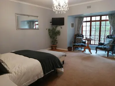 a bedroom with a bed and a chandelier at Mooring House in Somerset West