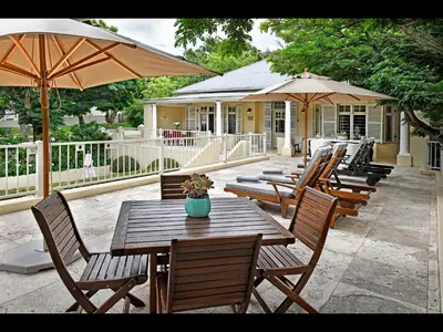 a row of wooden tables and chairs with umbrellas at Auberge Daniella in Franschhoek