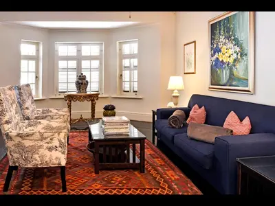 a living room with a blue couch and a chair at Auberge Daniella in Franschhoek