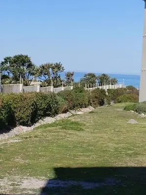 a shadow of a person on the grass near a lighthouse at MarineView Getaway in Hermanus