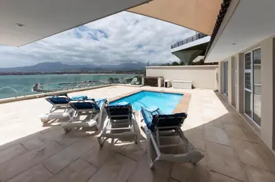 a swimming pool on the roof of a house at 'Harbour Views' - 2 bedroom, sleeps 4 with private pool and large veranda! in Gordonʼs Bay
