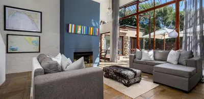 a living room with two couches and a fireplace at Two Bedroom Soutpan Apartment in Hermanus