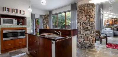 a kitchen with a sink and a stone wall at Two Bedroom Soutpan Apartment in Hermanus