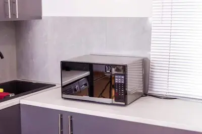 a microwave oven sitting on a counter in a kitchen at 3 on The Fairway Pinelands in Cape Town