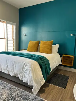 a bedroom with a large bed with a blue wall at Hermanus Waterfront Apartment no 17 in Hermanus