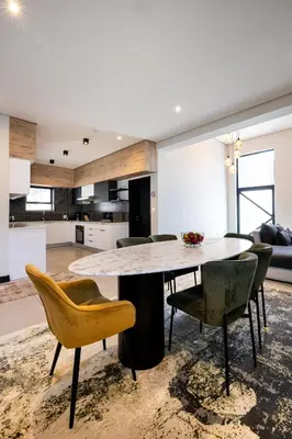 a kitchen and living room with a table and chairs at Phoenix Home in Cape Town