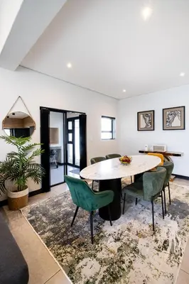 a living room with a table and chairs at Phoenix Home in Cape Town