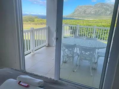 a room with a balcony with a table and chairs at Views galore in Kleinmond in Kleinmond