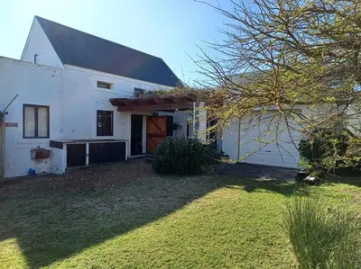 a white barn with a large yard in front of it at Chillilabombwe in Pringle Bay