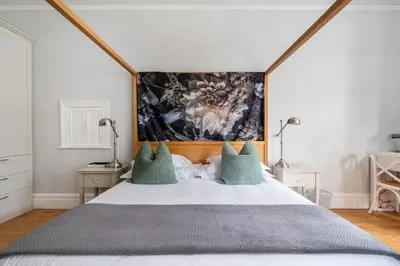 a bedroom with a large bed with blue pillows at Bonne Esperance Studio Apartments in Stellenbosch