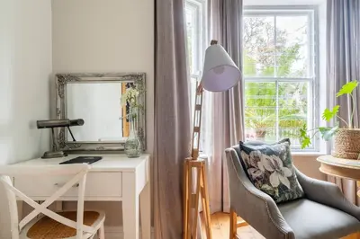 a room with a desk and a chair and a mirror at Bonne Esperance Studio Apartments in Stellenbosch