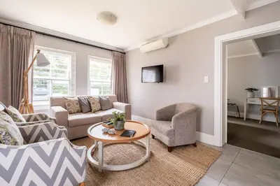 a living room with a couch and a table at Bonne Esperance Studio Apartments in Stellenbosch