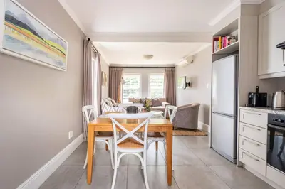 a kitchen and dining room with a table and chairs at Bonne Esperance Studio Apartments in Stellenbosch
