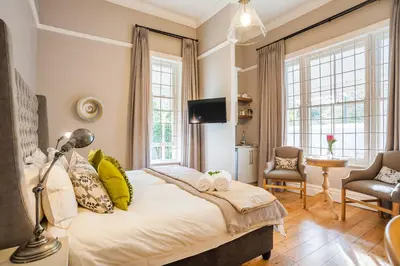a bedroom with a large bed and a tv at Bonne Esperance Studio Apartments in Stellenbosch