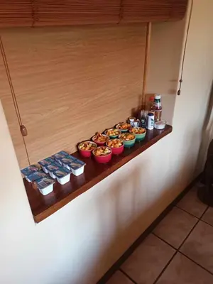 a row of bowls of food on a shelf at Pentzhaven Guesthouse in Table View