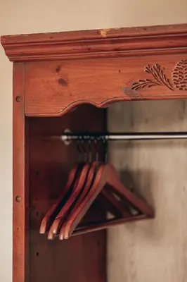 a wooden cabinet with a rack of utensils at Villa Chad Luxury Guesthouse in Kleinmond