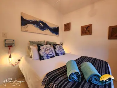 a bedroom with a bed with blue towels on it at Seaside Charm in Gordonʼs Bay