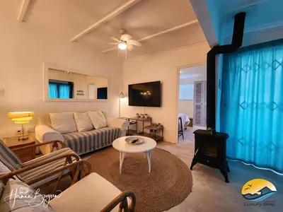 a living room with a couch and a stove at Seaside Charm in Gordonʼs Bay