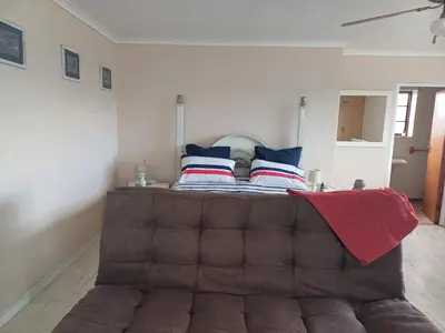 a bed with a brown tufted headboard in a room at Dukes Place in Hermanus