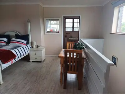 a bedroom with a bed and a table and chairs at Dukes Place in Hermanus
