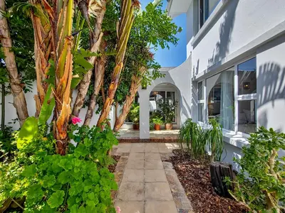 a courtyard of a house with palm trees at Strand Boat House in Cape Town