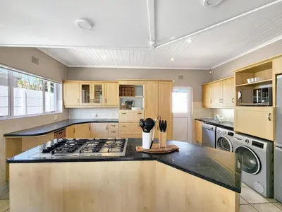 a kitchen with a stove and a counter top at Strand Boat House in Cape Town