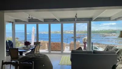 a living room with a view of the ocean at Onrus Sunset Beach House in Hermanus