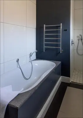 a bath tub in a bathroom with a shower at Pelicans Nest in Onrus in Hermanus