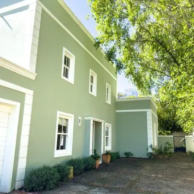 a large white house with a green at The hidden Retreat on Haumann in Franschhoek