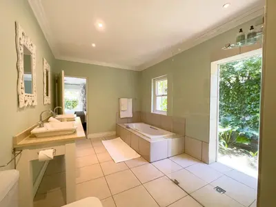 a bathroom with a tub and a sink at The hidden Retreat on Haumann in Franschhoek