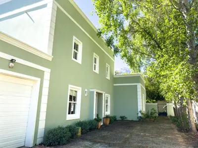 a green house with a white at The hidden Retreat on Haumann in Franschhoek