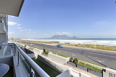 a view of the beach from the balcony of a building at Sea Spray B104 in Table View