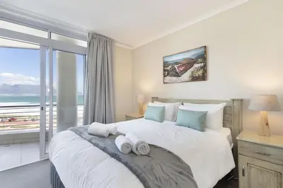 a bedroom with a large bed with towels on it at Portico 405 in Bloubergstrand