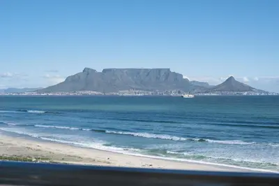 a view of the beach with a mountain in the background at Portico 704 in Bloubergstrand
