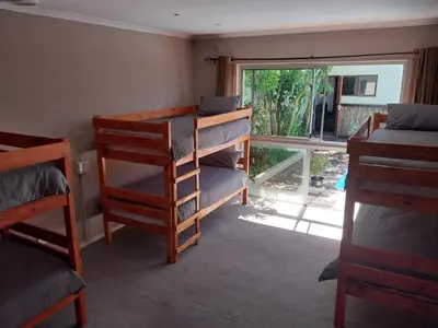 a room with two bunk beds and a window at Serenity Shores Backpackers in Cape Town