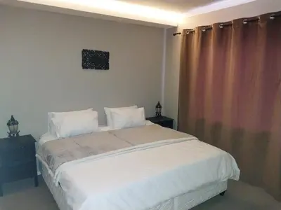 a bedroom with a large bed with white sheets and pillows at Serenity Shores Backpackers in Cape Town