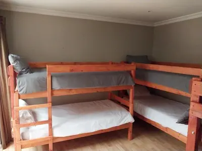 a bedroom with three bunk beds in a room at Serenity Shores Backpackers in Cape Town
