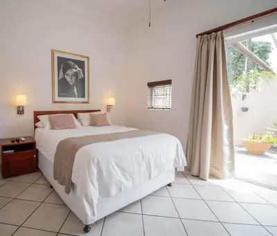 a bedroom with a large bed and a window at Broadway Boston in Cape Town