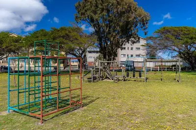 an empty park with a playground in the grass at Burmeister 606 - Top Floor 2 Bedroom Apartment with Ocean Views - Onsite Parking in Cape Town