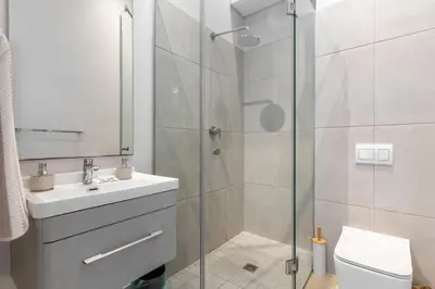 a bathroom with a shower and a sink and a toilet at Burmeister 606 - Top Floor 2 Bedroom Apartment with Ocean Views - Onsite Parking in Cape Town