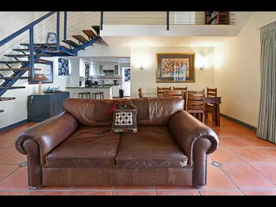 a brown leather couch sitting in a living room at Sunflower Villa in Franschhoek in Franschhoek