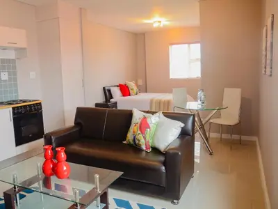 a living room with a couch and a bed at The Brookston in Cape Town