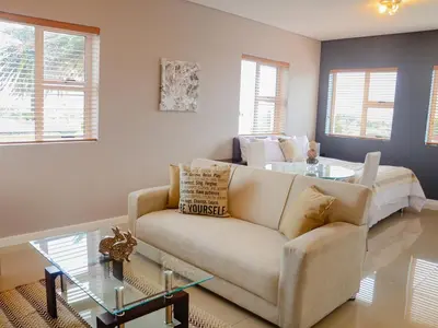 a living room with a couch and a glass table at The Brookston in Cape Town