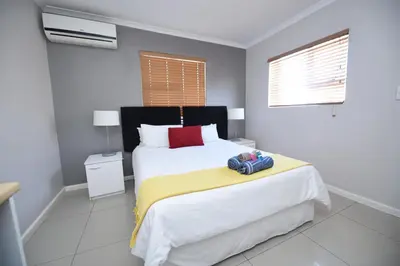 a bedroom with a large white bed and a window at The Brookston in Cape Town