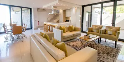 a living room with a couch and chairs and a table at Harbour House Hotel - Le Paradis Apartments in Hermanus