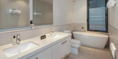 a bathroom with two sinks and a toilet at Harbour House Hotel - Le Paradis Apartments in Hermanus