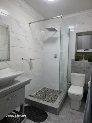 a bathroom with a shower with a toilet and a sink at Elite Escape in Cape Town