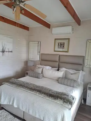 a large white bed in a bedroom with a ceiling at Milky Way in Hermanus