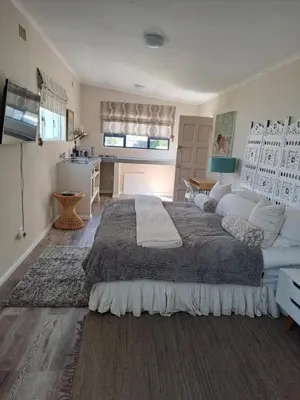 a large bedroom with a large bed and a kitchen at Milky Way in Hermanus