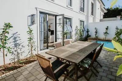 a patio with a wooden table and chairs at Quiet Hideaway in Somerset West